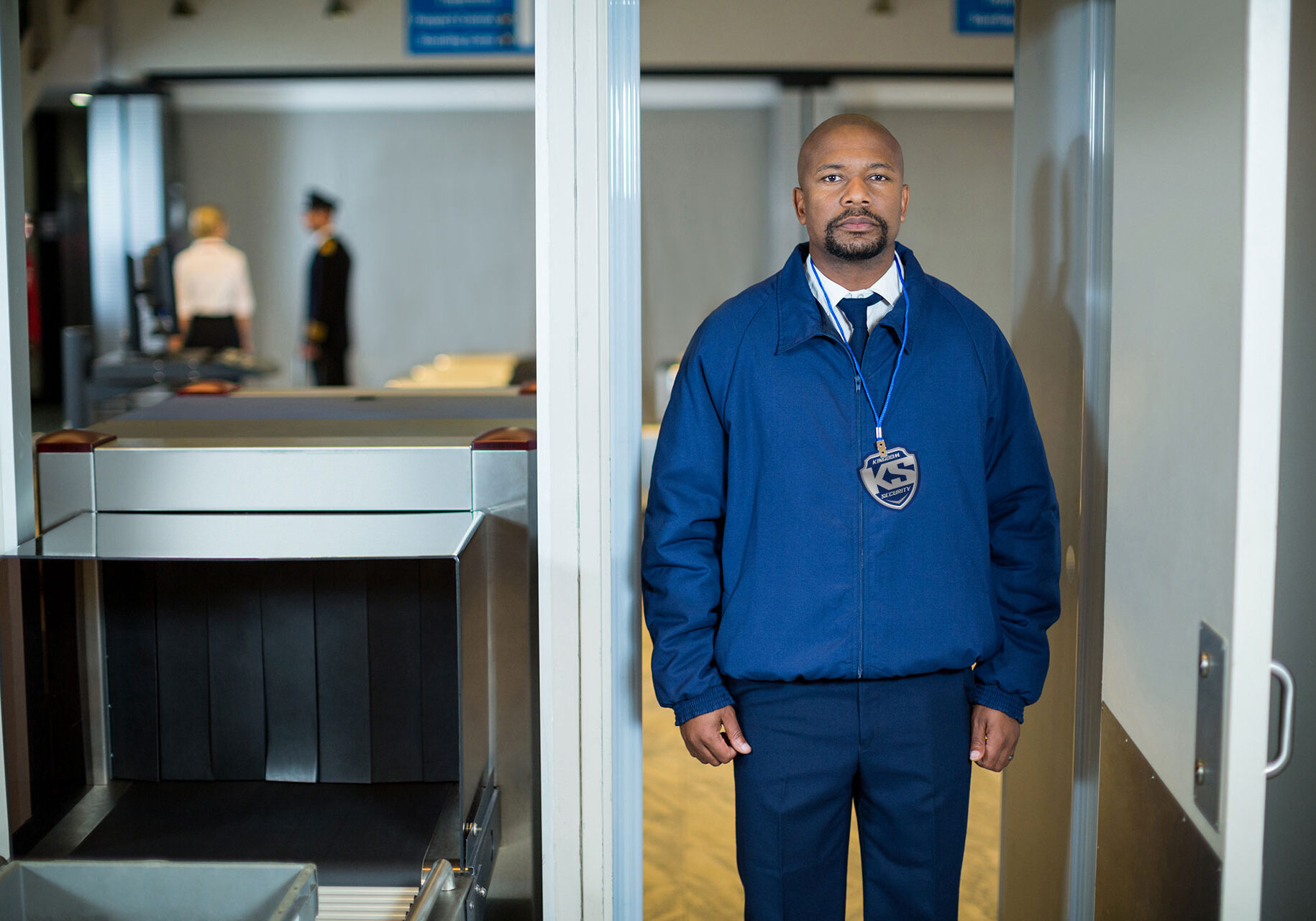 airport-security-officer-standing-metal-detector-door